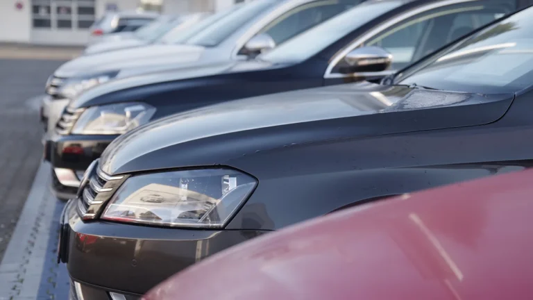 Cars lined up in a dealership.